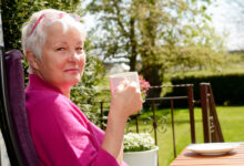 Senior woman with cup in garden happy old lady tea garden terrace balcony