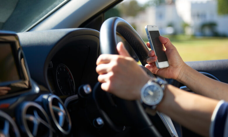 Young woman texting while driving