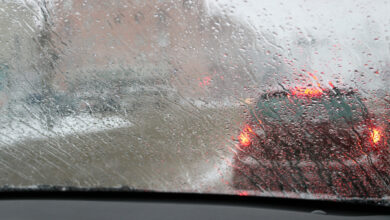 View from the car windscreen during rain and wet snow. Poor visibility while driving around the city. Snowy road.