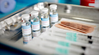 Close up of Vials and Syringes with Covid-19 vaccine are displayed on a tray during vaccination.