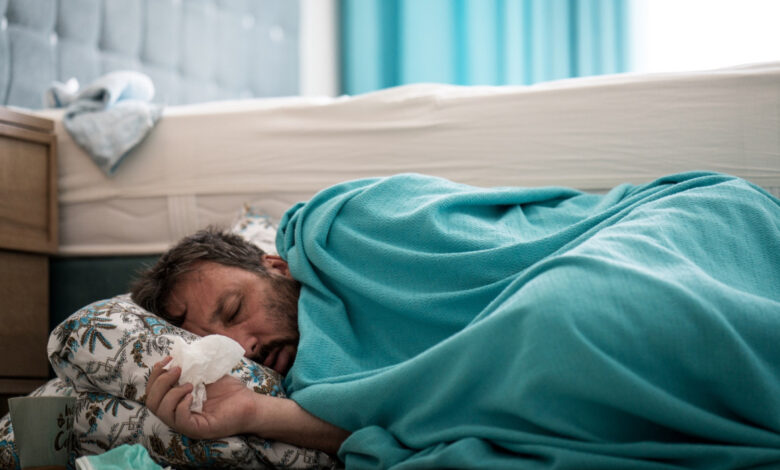 Sick man with fever on ground in bedroom