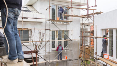 Workers on renovation site doing insulation facade on walls