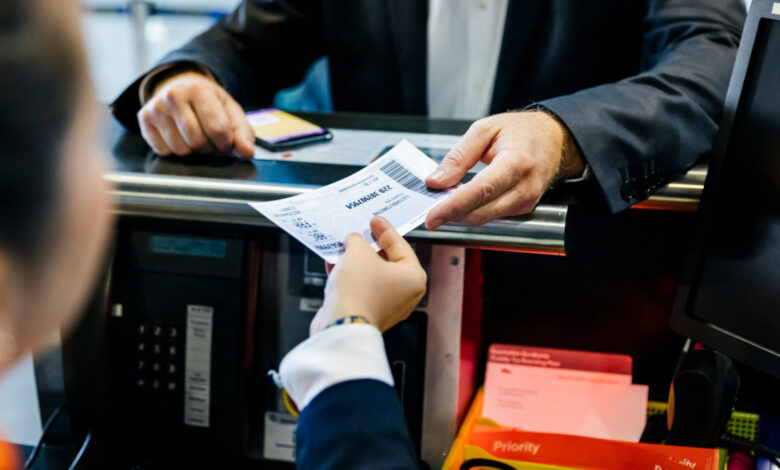 Close-up shot of a businessmans hand getting his boarding pass at check-in counter